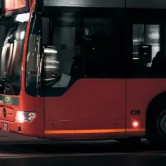 Czerwony autobus miejski w ruchu. Zastanawiasz się, ile kosztuje prawo jazdy na autobus?