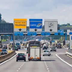 Autostrada we Włoszech z punktem poboru opłat, znakami Telepass, Carte i symbolami płatności.