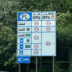 Tablica informuje o ograniczeniach prędkości w Polsce dla różnych pojazdów i typów dróg.