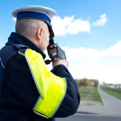 Policjant mierzy prędkość. Zastanawiasz się, ile kosztuje zbicie punktów karnych? Lepiej zwolnij!