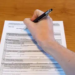 Dłoń z długopisem wypełniająca polski formularz podatkowy PCC-3/A.