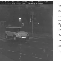 Zdjęcie z fotoradaru: biały Land Rover Defender na pasach, przekracza limit prędkości 50 km/h.