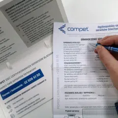 Dłoń z długopisem wypełniająca formularz oświadczenia sprawcy kolizji drogowej.