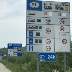Znaki drogowe informują o opłatach i limitach prędkości na drodze ekspresowej. Kierowcy powinni zwracać uwagę na znaki, aby przestrzegać przepisów i zapewnić bezpieczeństwo.