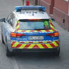 Niemiecki radiowóz z niebieskimi światłami i odblaskowymi pasami. Może wystawić mandaty w Niemczech.