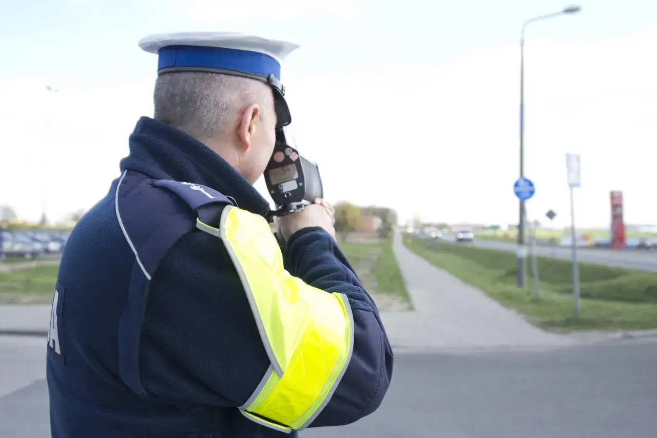 Policjant mierzy prędkość, by ustalić, ile kosztuje zbicie punktów karnych.